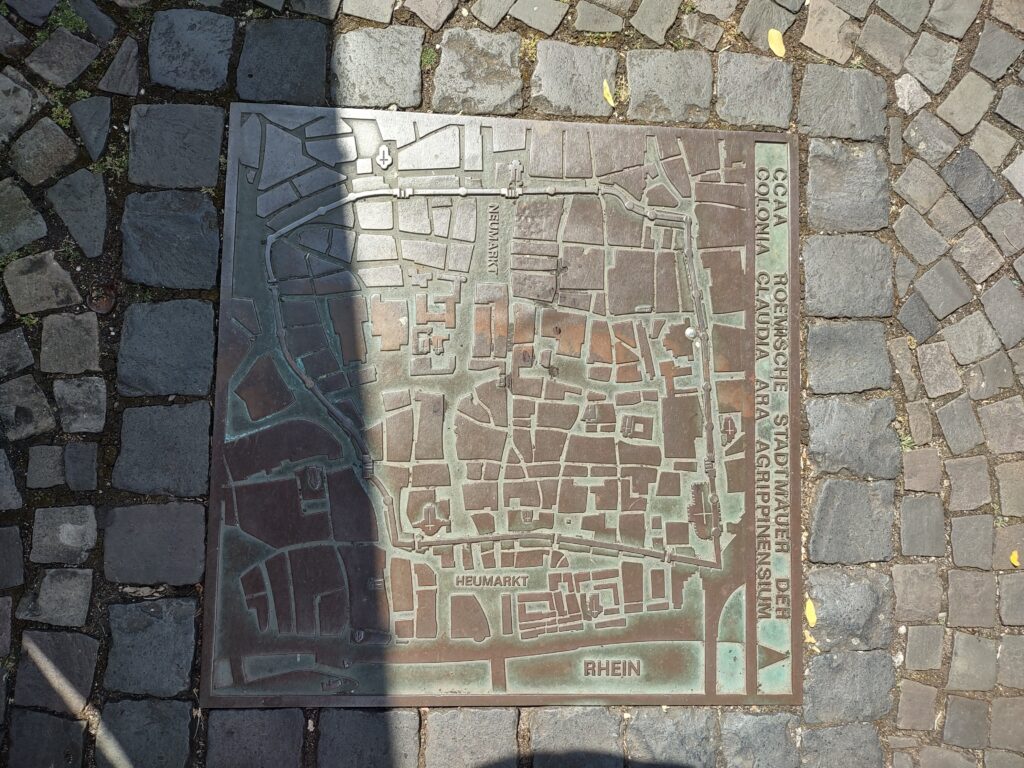 Sidewalk sewer panel with map of ancient roman wall